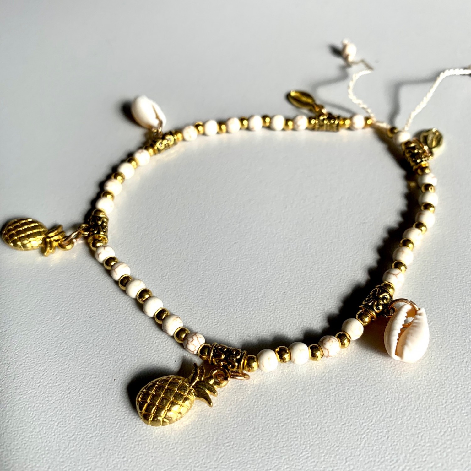 Enkelbandje met goud/witte kraaltjes, ananas en schelpjes