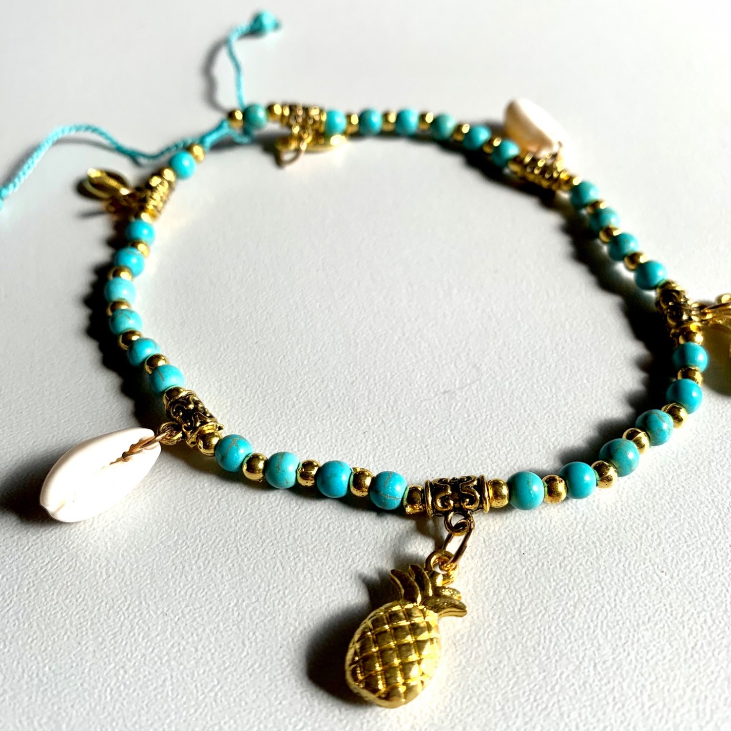 Enkelbandje met goud/turquoise kraaltjes, ananas en schelpjes